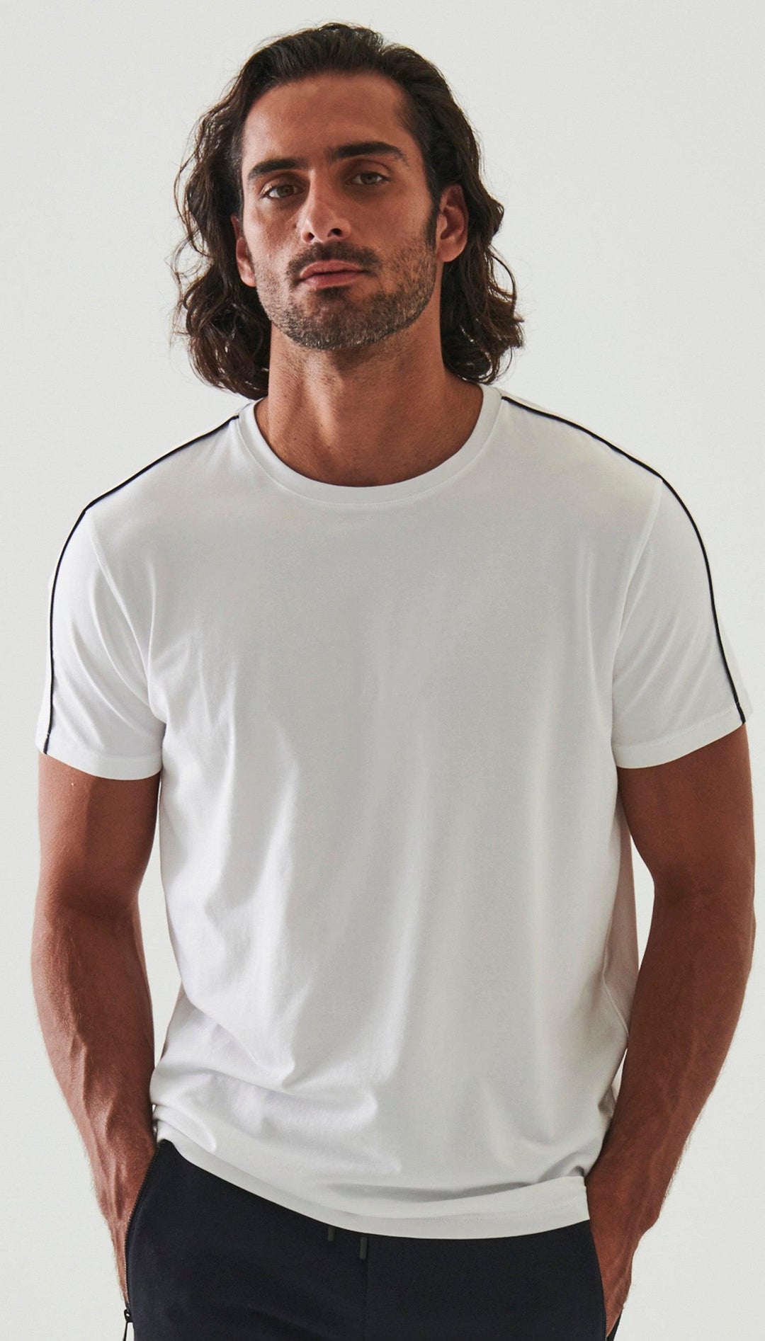 The ultimate in comfort and softness, this ultra soft pima cotton tee sports a fine contemporary style.  Crisp white with a raised black accent along the shoulders and down the sleeve. Soft pima cotton. Designed by Assaraf Italy. Classic tee shirt model Open sleeves and bottom. Modern fit, perfect for a slim to medium build.
